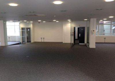 A refurbished room with carpet flooring. Individual rooms with walls of glass